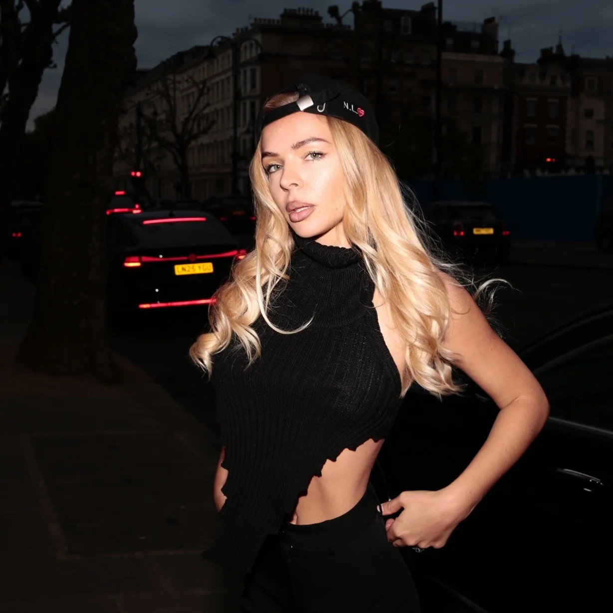 Woman in a backwards cap photographed on a London street at dusk